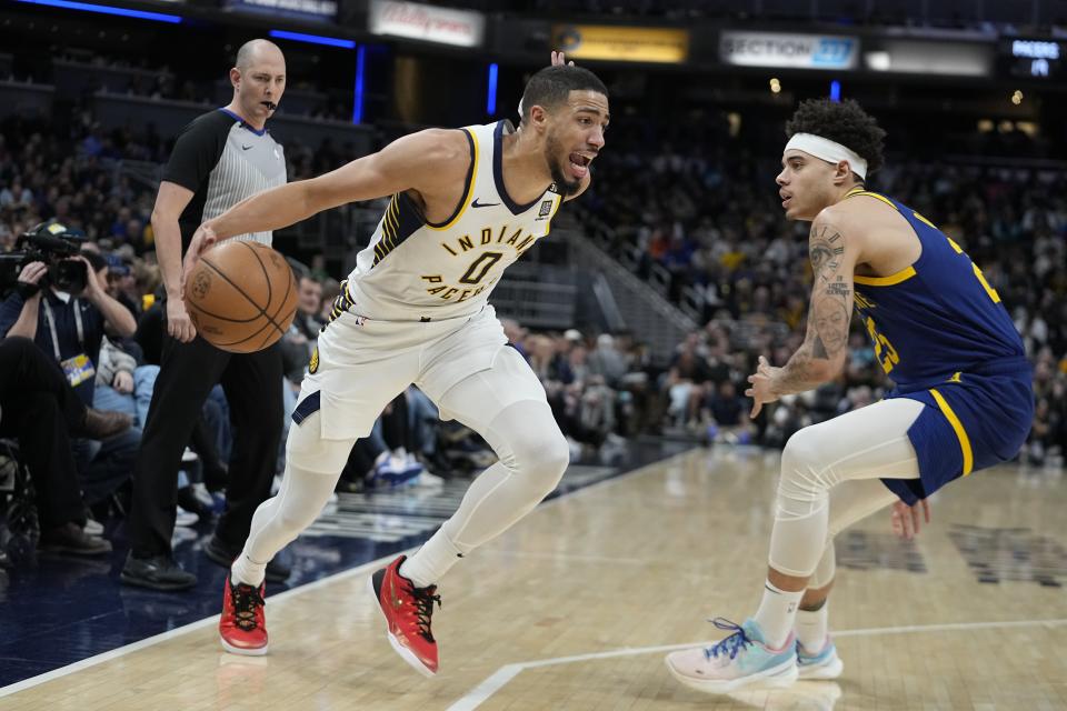 Indiana Pacers' Tyrese Haliburton (0) is defended by Golden State Warriors' Lester Quinones (25) during the first half of an NBA basketball game Thursday, Feb. 8, 2024, in Indianapolis. (AP Photo/Darron Cummings)