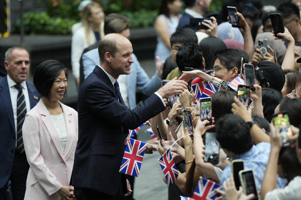 Britain's Prince William, center, with Sim Ann, Senior Minister of State for Foreign Affairs of Singapore, is greeted by public as they arrive at Jewel in Changi airport, Singapore, Sunday, Nov. 5, 2023. (AP Photo/Vincent Thian)