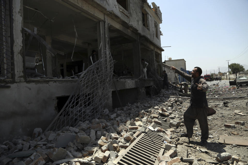 Afghan men search for the remains of their belongings at their shops following a suicide attack in Kabul, Afghanistan, Thursday, July 25, 2019. Three bombings struck the Afghan capital on Thursday, killing at least eight people, including five women and one child, officials said Thursday. (AP Photo/Rahmat Gul)