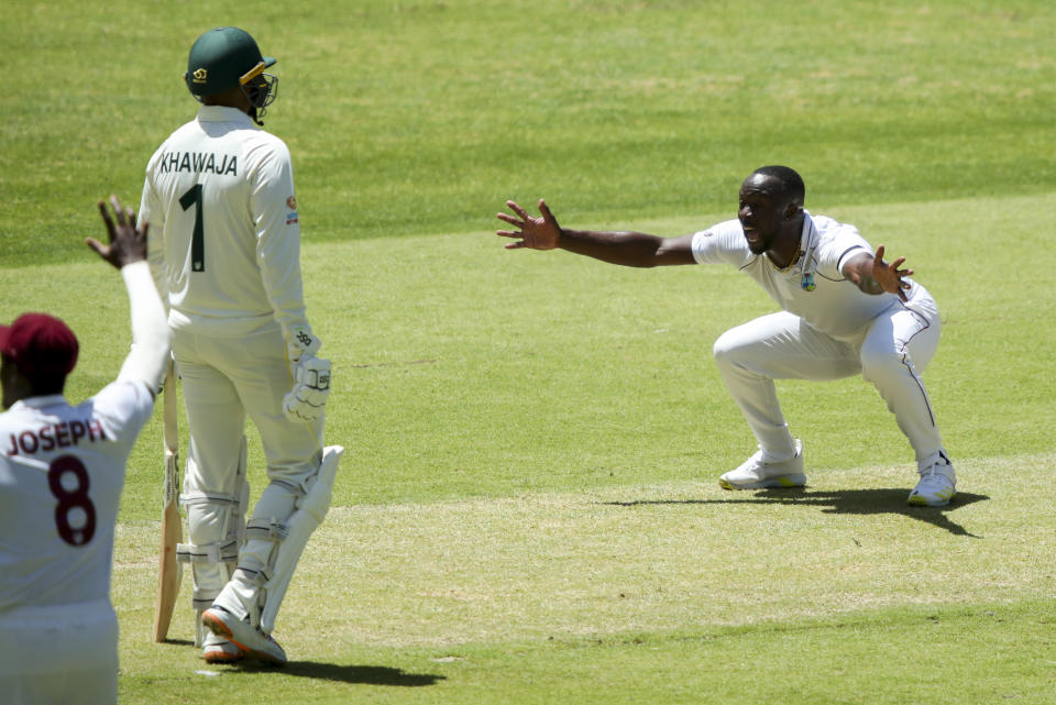 West Indies' Kemar Roach appeals unsuccessfully for a wicket as Australia's Usman Khawaja, left, watches during play on the first day of the first cricket test between Australia and the West Indies in Perth, Australia, Wednesday, Nov. 30, 2022. (AP Photo/Gary Day)