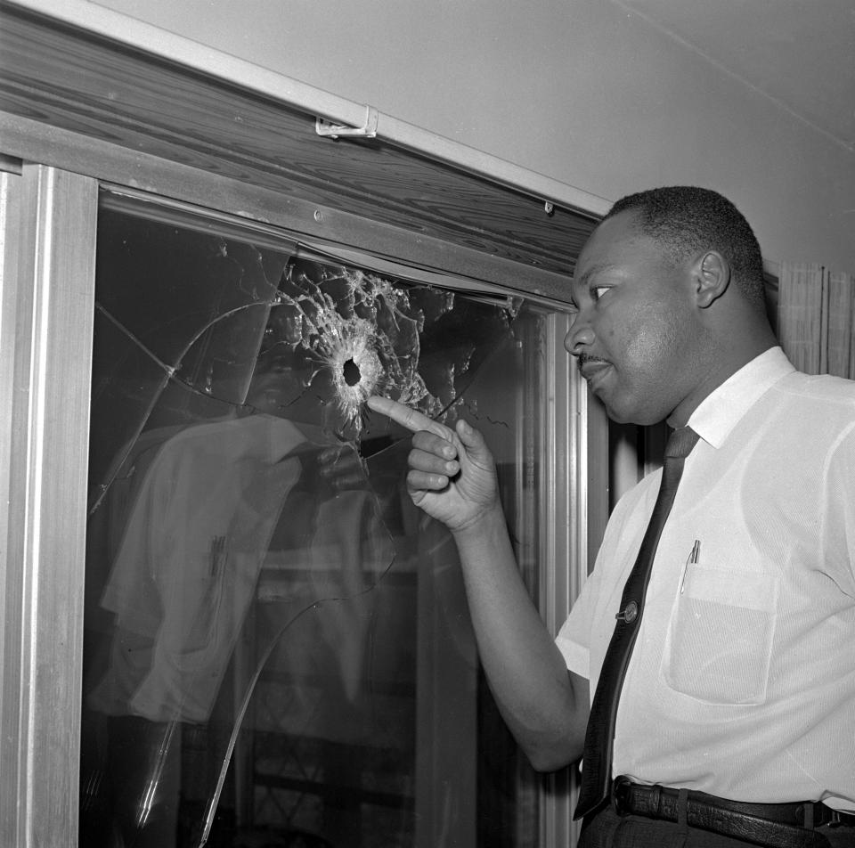The Rev. Martin Luther King Jr. points to a bullet hole in a glass sliding door of a home he was scheduled to stay in on Atlantic View, south of St. Augustine, in 1964.