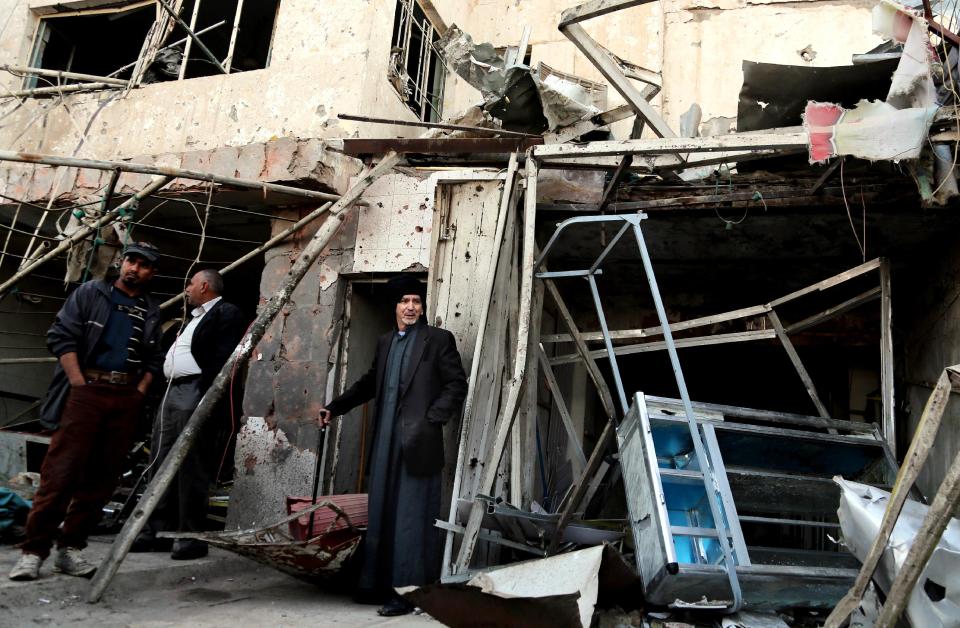 Civilians inspect the site of a car bomb attack in the eastern Ur neighborhood of Baghdad, Iraq, Tuesday, Feb. 18, 2014. A wave of explosions rocked mainly Shiite neighborhoods in Baghdad shortly after sunset on Monday, killing and wounding scores of people, said Iraqi officials. (AP Photo/Karim Kadim)