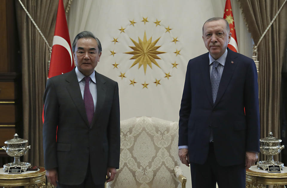 Turkey's President Recep Tayyip Erdogan, right, and Chinese Foreign Minister Wang Yi pose for photos before a meeting, in Ankara, Turkey, Thursday, March 25, 2021. Hundreds of Uyghurs staged protests in Ankara and Istanbul on Thursday, denouncing Wang Yi's visit to Turkey and demanding that the Turkish government take a stronger stance against human rights abuses in China's far-western Xinjiang region. (Turkish Presidency via AP, Pool)