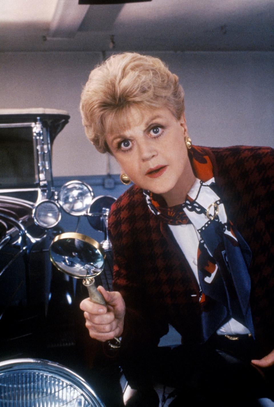 Angela Lansbury holding a mignifying glass