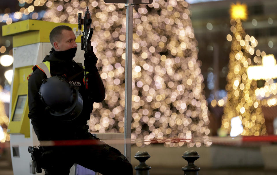 A police officer secures the evacuated Christmas market at the Breitscheidplatz in Berlin, Germany, Saturday, Dec. 21, 2019 after a suspicious object was found at the Christmas market. (AP Photo/Michael Sohn)