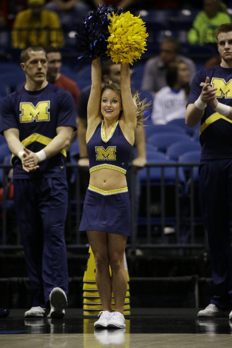 Michigan cheerleaders perform before an NCAA Midwest Regional semifinal college basketball tournament game between the Michigan and the Tennessee Friday, March 28, 2014, in Indianapolis. (AP Photo/David J. Phillip)