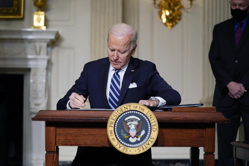 FILE - In this Jan. 27, 2021 file photo, President Joe Biden signs an executive order on climate change, in the State Dining Room of the White House in Washington. Biden is convening a coalition of the willing, the unwilling, the desperate-for-help and the avid-for-money for a two-day summit aimed at rallying the world’s worst polluters to do more to slow climate change. Biden’s first task when his virtual summit opens Thursday is to convince the world that the United States is both willing and able isn’t just willing to meet an ambitious new emissions-cutting pledge, but also able. (AP Photo/Evan Vucci)