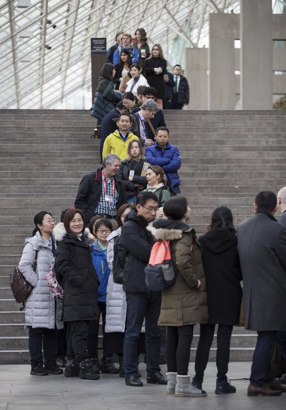 Members of the media and public line up to enter a courtroom to attend a hearing for Huawei chief financial officer Meng Wanzhou, who is out on bail and remains under partial house arrest after she was detained last year at the behest of American authorities, at B.C. Supreme Court, in Vancouver, on Tuesday January 21, 2020. (Darryl Dyck/The Canadian Press via AP)