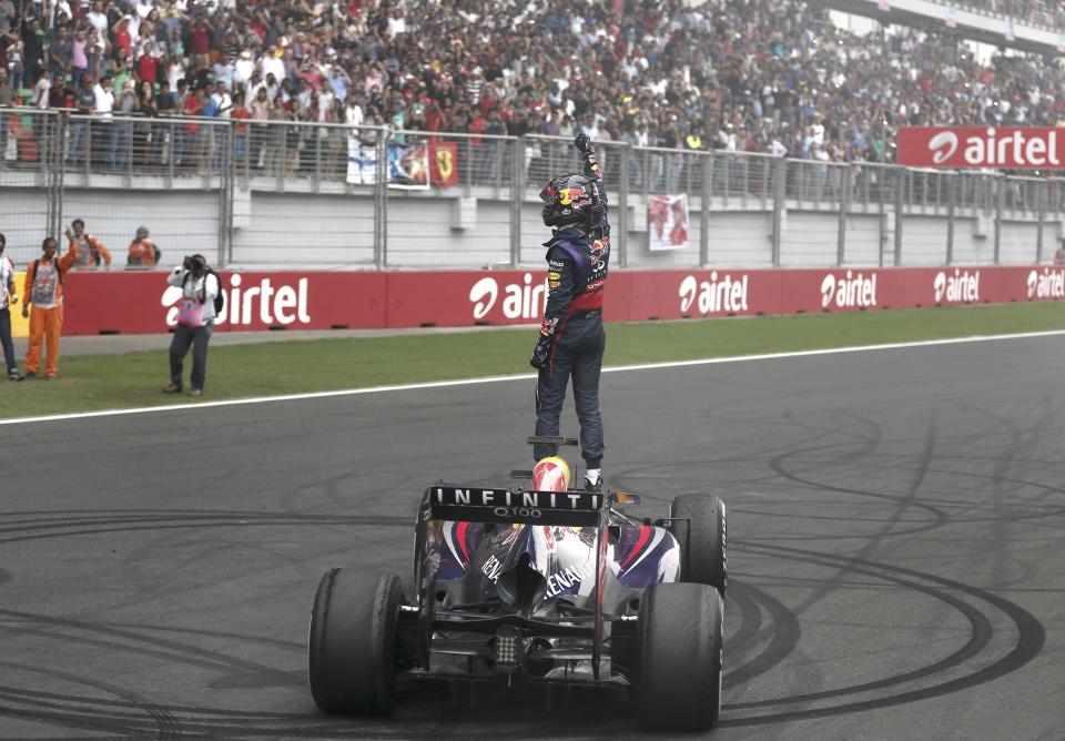 Red Bull Formula One driver Vettel celebrates atop his car after winning the Indian F1 Grand Prix at the Buddh International Circuit in Greater Noida