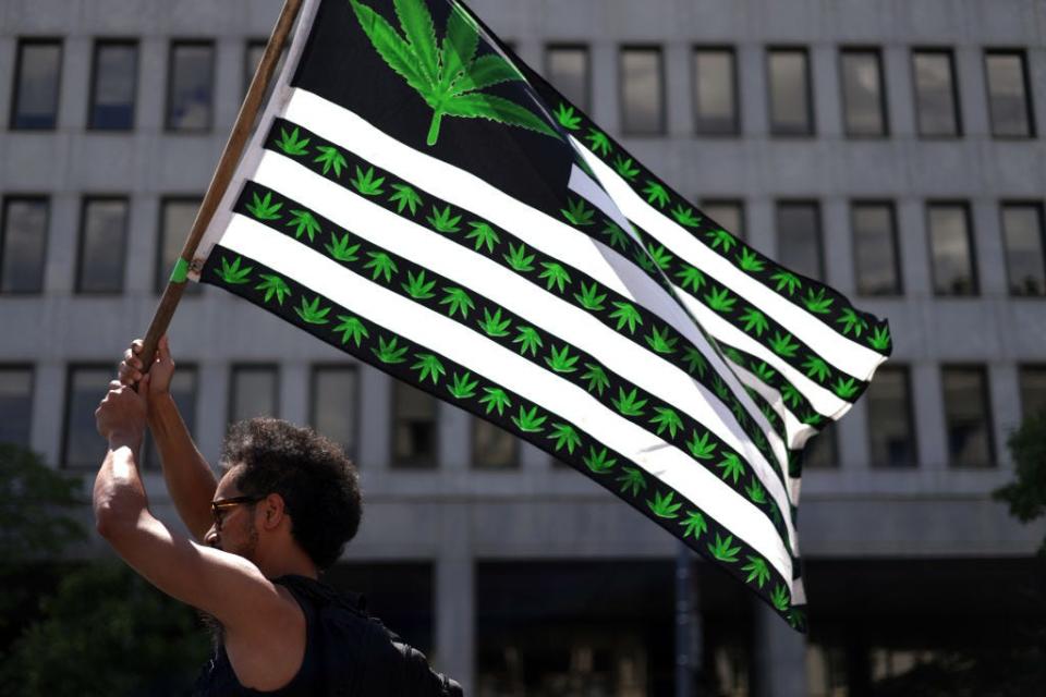 A marijuana activist holds a flag during a march on Independence Day on July 4, 2021 in Washington, DC.