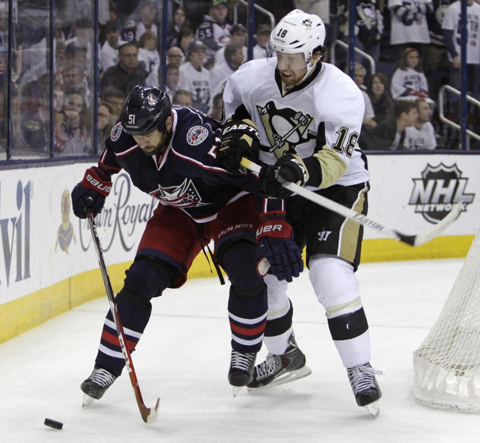 Columbus Blue Jackets' Fedor Tyutin, left, of Russia, tries to keep the puck away from Pittsburgh Penguins' James Neal during the third period of Game 6 of a first-round NHL playoff hockey series Monday, April 28, 2014, in Columbus, Ohio. The Penguins advance to the second round with their 4-3 win over the Blue Jackets. (AP Photo/Jay LaPrete)