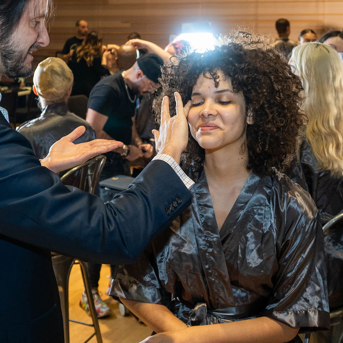 Dr. Dusan applies Sajic Skincare to model backstage at fashion show