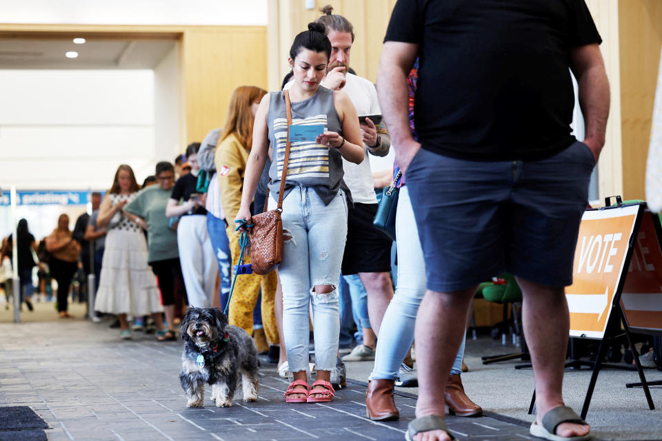 A voter waits in a long line with her dog on the last day of the state's early voting for the 2022 midterm elections on Nov. 5, 2022, in Chapel Hill, North Carolina.