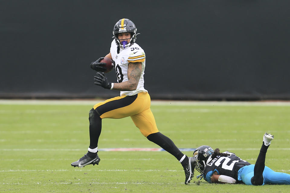 Pittsburgh Steelers running back James Conner, left, slips past Jacksonville Jaguars cornerback Chris Claybrooks for a gain during the first half of an NFL football game, Sunday, Nov. 22, 2020, in Jacksonville, Fla. (AP Photo/Matt Stamey)