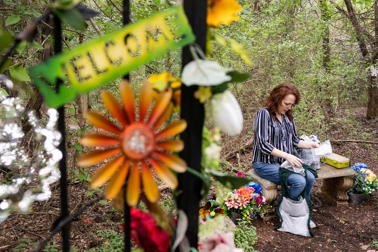 Elizabeth Crecente sorts through decorations to place around Jennifer's Garden Friday, June 23, 2023. Jennifer Crecente, Elizabeth's daughter, was killed in 2006 by her ex-boyfriend. Since then, Elizabeth has transformed the space Jennifer was murdered into a colorful garden that honors her life.