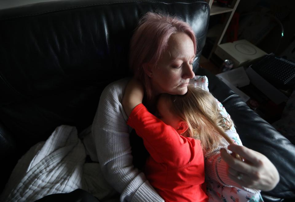 Rebekah Hogan lies with her son Sebastian, 9, in the living room of their home in Troy, N.Y. April 7, 2022. The family of five, including Rebekah's husband James, a disabled military veteran, contracted COVID-19 in late 2020. Almost a year and a half later, they all suffer symptoms of long COVID. James, who is permanently disabled, has had to take on the role of caregiver for his family despite his lingering symptoms. Rebekah, a registered nurse, has been unable to work due to her COVID symptoms. As a result the family has eaten into much of their life savings. 
