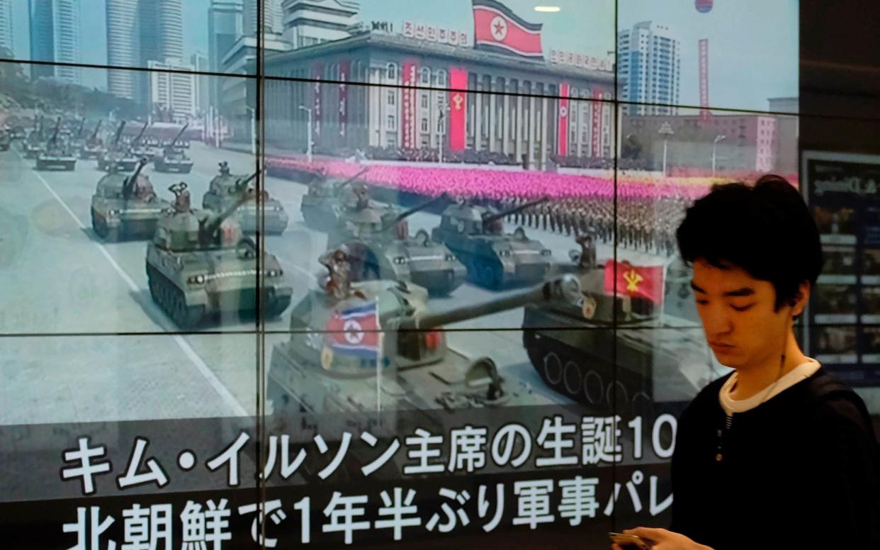 A man walks in front of a news showing a North Korean milittary parade, in Tokyo - AFP