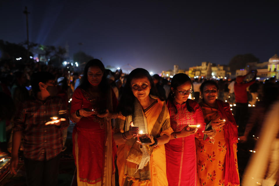 People light lamps on the banks of the river Saryu in Ayodhya, India, Wednesday, Nov. 3, 2021. Over 900,000 earthen lamps were lit and were kept burning for 45 minutes as the north Indian city of Ayodhya retained its Guinness World Record for lighting oil lamps as part of the Diwali celebration – the Hindu festival of lights. (AP Photo/Rajesh Kumar Singh)