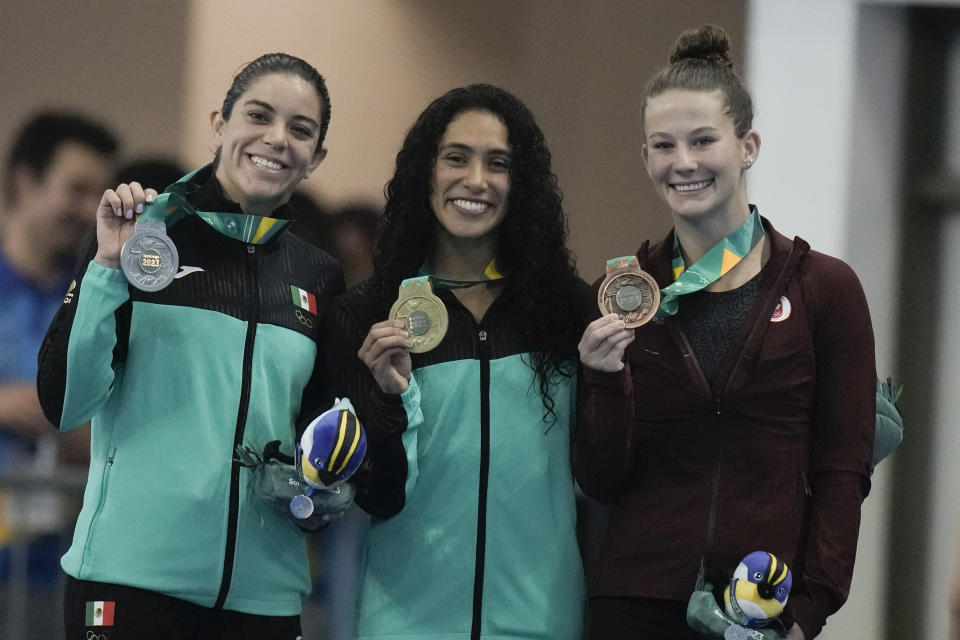 Desde la izquierda, las mexicanas Alejandra Orozco y Gabriela Agúndez, posan con la canadiense Caeli Mckay en el podio tras la final de la plataforma sincronizada de 10 metros femenina de los Juegos Panamericanos en Santiago, Chile, el lunes, 23 de octubre de 2023. (AP Foto/Eduardo Verdugo)