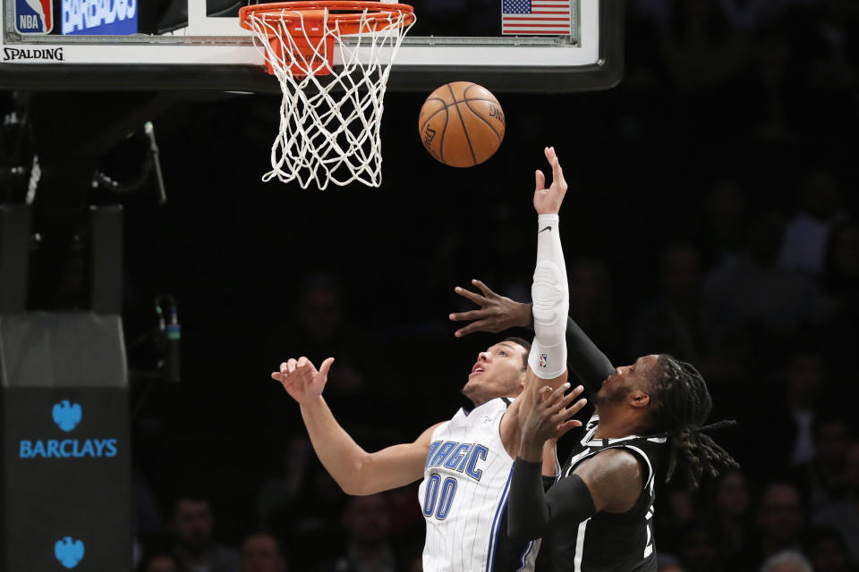 Brooklyn Nets forward Taurean Prince, right, becomes entangled with Orlando Magic forward Aaron Gordon (00) beneath the Magic basket during the second quarter of an NBA basketball game, Monday, Feb. 24, 2020, in New York. (AP Photo/Kathy Willens)