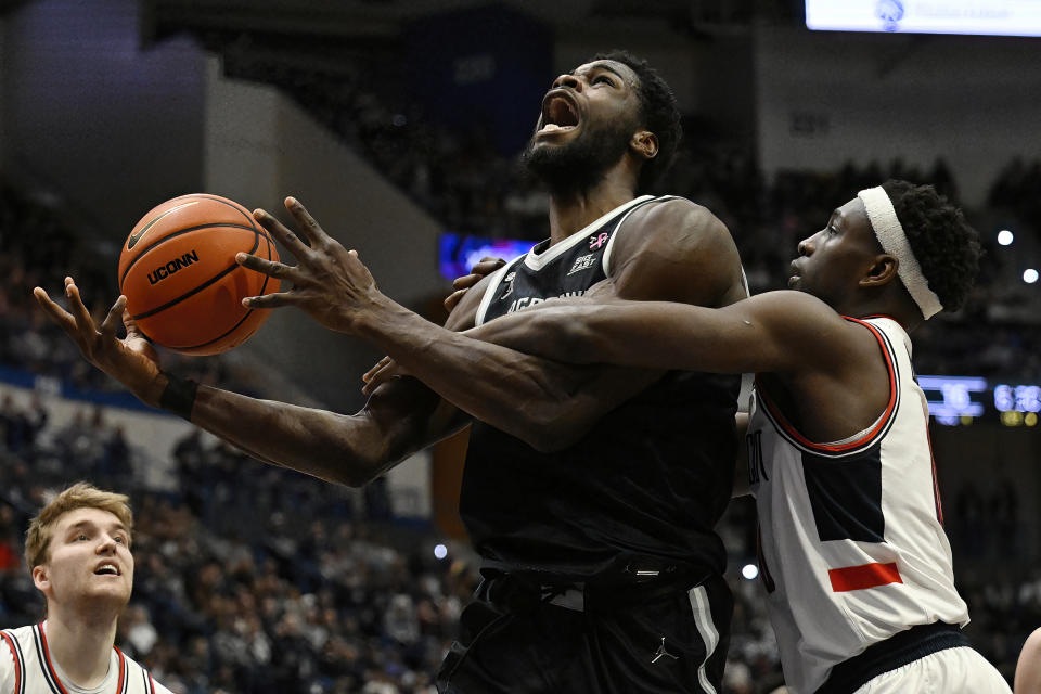 UConn guard Hassan Diarra, right, fouls Georgetown forward Supreme Cook in the first half of an NCAA college basketball game, Sunday, Jan. 14, 2024, in Hartford, Conn. (AP Photo/Jessica Hill)