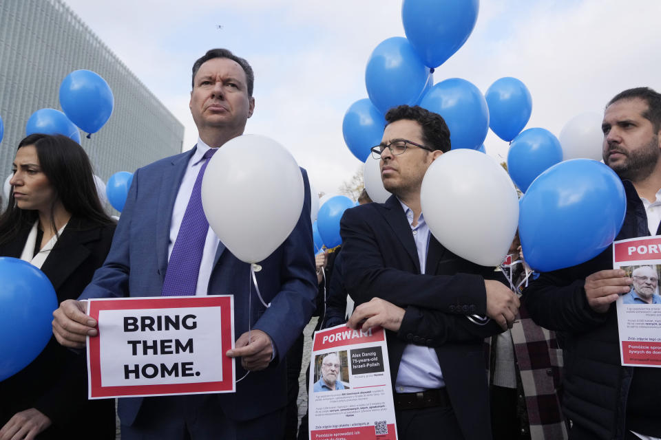 Israeli Ambassador to Poland, Yacov Livne, second left, and Yuval Danzig, the son of a Polish-Israeli man held by Hamas, Alex Dancyg, attend a demonstration held in front of the POLIN Museum of the History of Polish Jews, in Warsaw, Poland, Friday, Oct. 27, 2023. (AP Photo/Czarek Sokolowski)