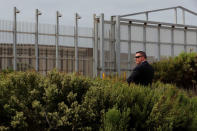 A security agent for Attorney General of California Xavier Becerra keeps watch as Becerra visits the U.S.-Mexico border to announce a lawsuit against the Trump Administration over its plans to begin construction of border wall in San Diego and Imperial Counties, in San Diego, California, U.S., September 20, 2017. REUTERS/Mike Blake