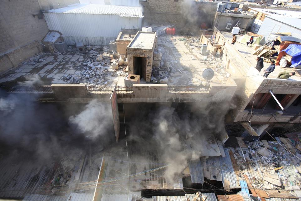 Smoke rises from the site of a bomb attack near Khullani Square in Baghdad