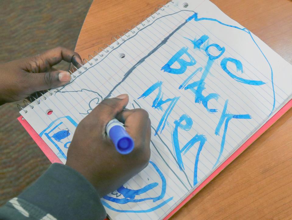 Tristan Pickett, a student in the 100 Black Men of Akron program, works on a drawing Friday.