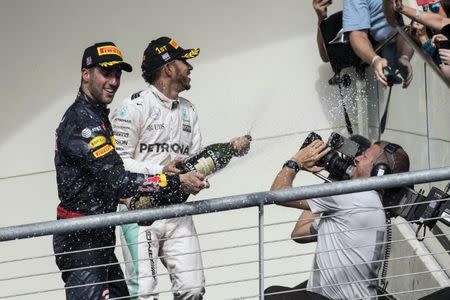 Oct 23, 2016; Austin, TX, USA; Mercedes driver Lewis Hamilton (44) of Great Britain and Red Bull Racing driver Daniel Ricciardo (3) of Australia spray champagne on their fans after the Circuit of the Americas. Mandatory Credit: Jerome Miron-USA TODAY Sports