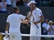 Ivo Karlovic of Croatia meets Jo-Wilfried Tsonga of France at the net after winning their match at the Wimbledon Tennis Championships in London, July 4, 2015. REUTERS/Toby Melville -