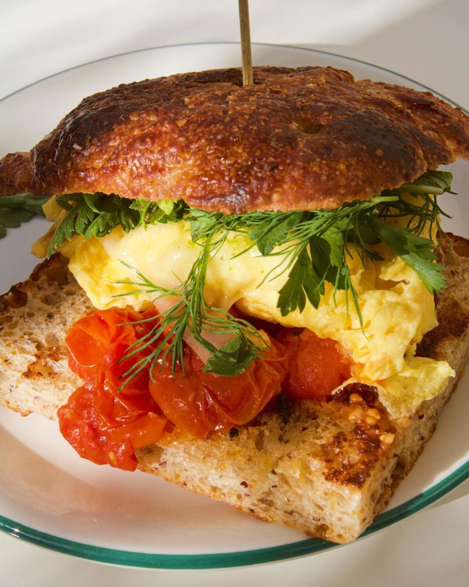 Vertical close-up of the herb- and sheep's-cheese-topped breakfast sandwich from all-day cafe Highly Likely in Highland Park