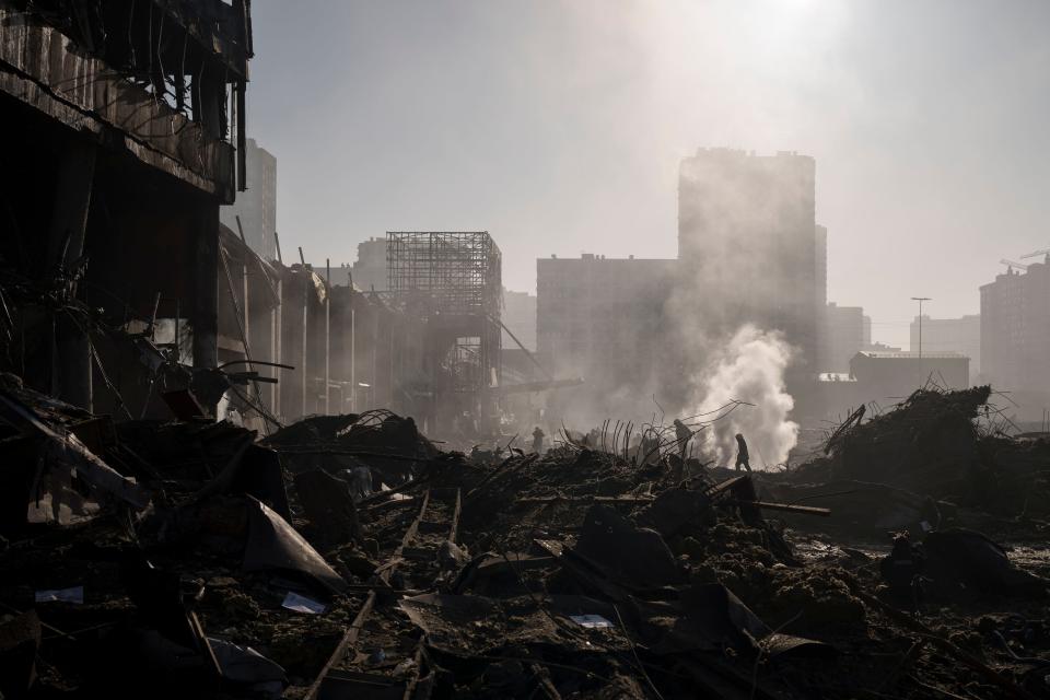 Firefighters extinguish a fire near a shopping center after shelling, in Kyiv, Ukraine on March 21.