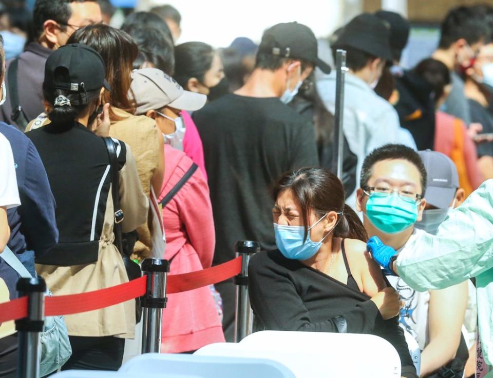 本土疫情升溫，民眾湧入台北車站接種疫苗。圖為民眾接種疫苗面露不適。（圖／粘耿豪攝）