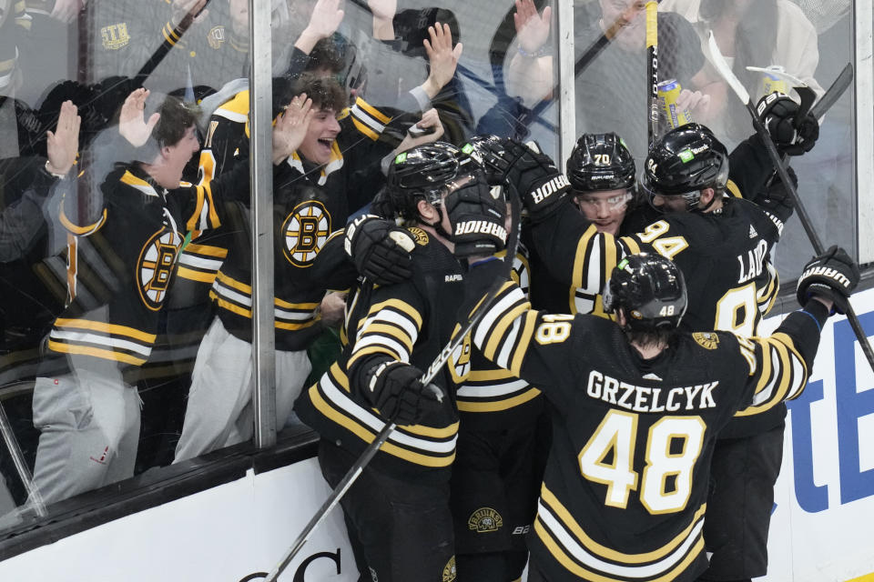 Fans and teammates celebrate after a goal by Boston Bruins defenseman Charlie McAvoy (73) during the second period of an NHL hockey game against the Carolina Hurricanes, Tuesday, April 9, 2024, in Boston. (AP Photo/Charles Krupa)