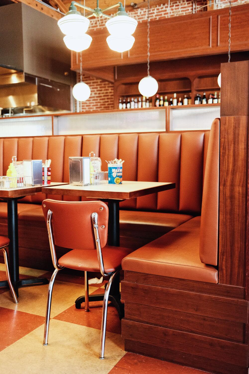 A vertical interior of a tan-colored chair and booth at Belle's Deli