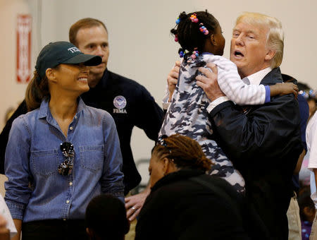 U.S. President Donald Trump lifts up a little girl as he and first lady Melania Trump visit with flood survivors of Hurricane Harvey at a relief center in Houston, Texas, U.S., September 2, 2017. REUTERS/Kevin Lamarque