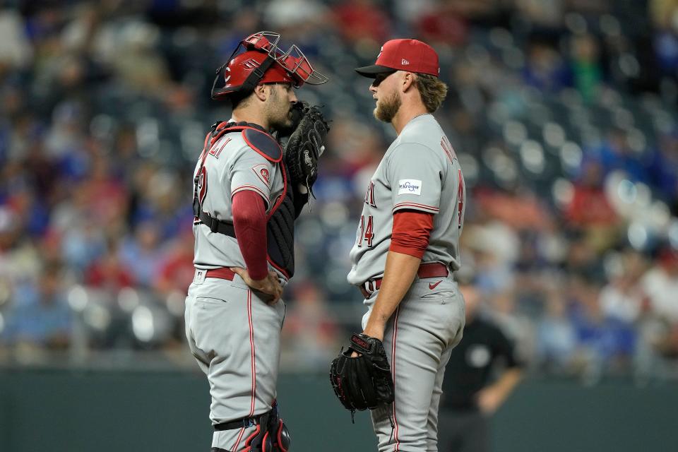 Cincinnati Reds relief pitcher Ricky Karcher and catcher Curt Casali meet on the mound during Monday's game against the Royals. Karcher earned the save in his MLB debut.