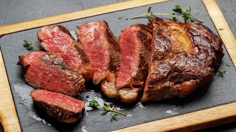 ribeye steak sliced on board