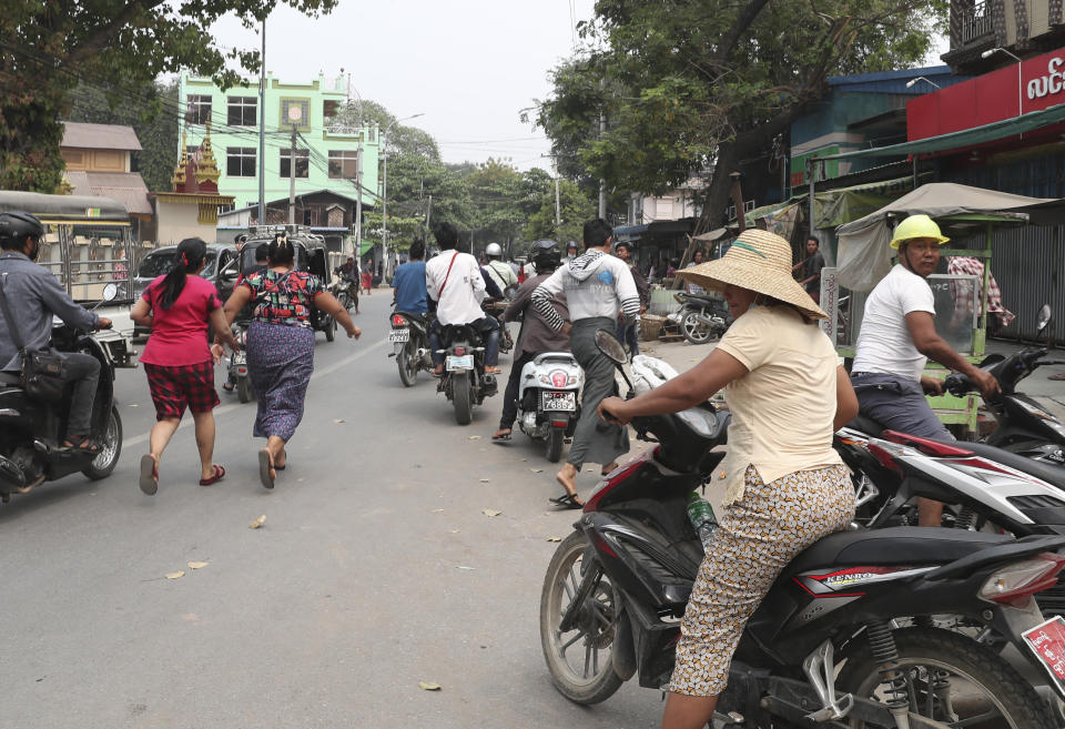 People flee as a convoy of soldiers and policemen arrive to remove makeshift barricades made by anti-coup protesters in Mandalay, Myanmar, Thursday, March 11, 2021. (AP Photo)