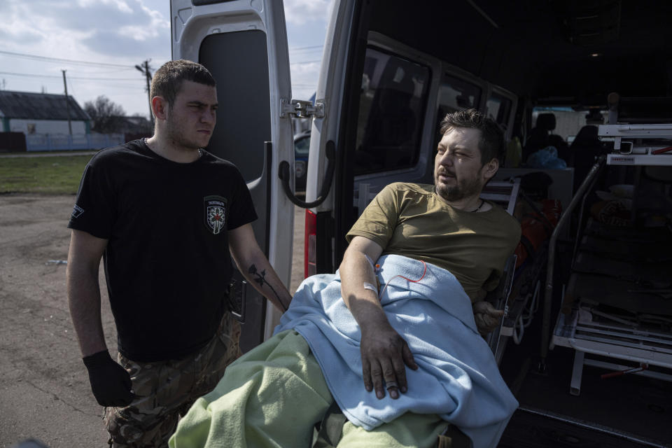 Yaroslav, 37, an injured Ukrainian soldier, lies on a stretcher before evacuation by volunteers from the Hospitallers paramedic organisation near a special medical bus in Donetsk region, Ukraine, Wednesday, March 22, 2023. (AP Photo/Evgeniy Maloletka)