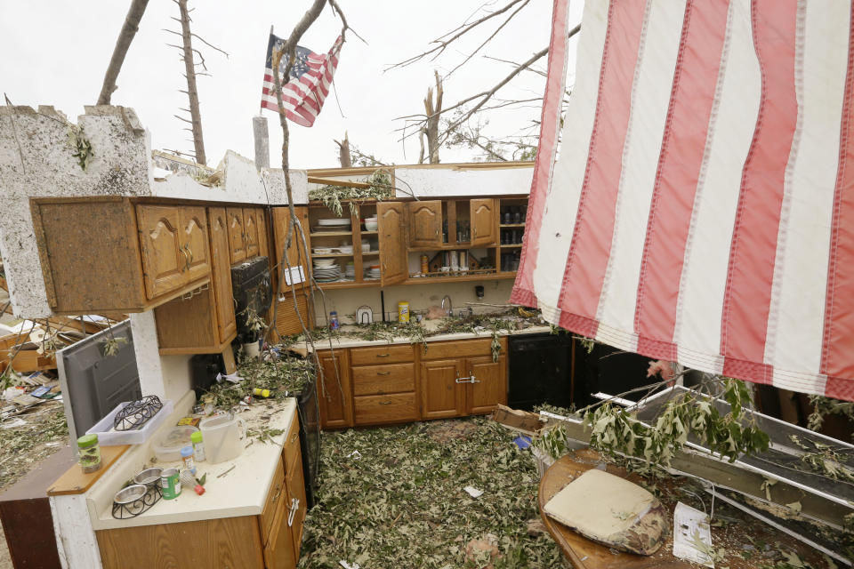 Flags fly over two walls that remain of a house in Mayflower, Ark., Tuesday, April 29, 2014. A dangerous storm system spawned a chain of deadly tornadoes over three days. (AP Photo/Danny Johnston)