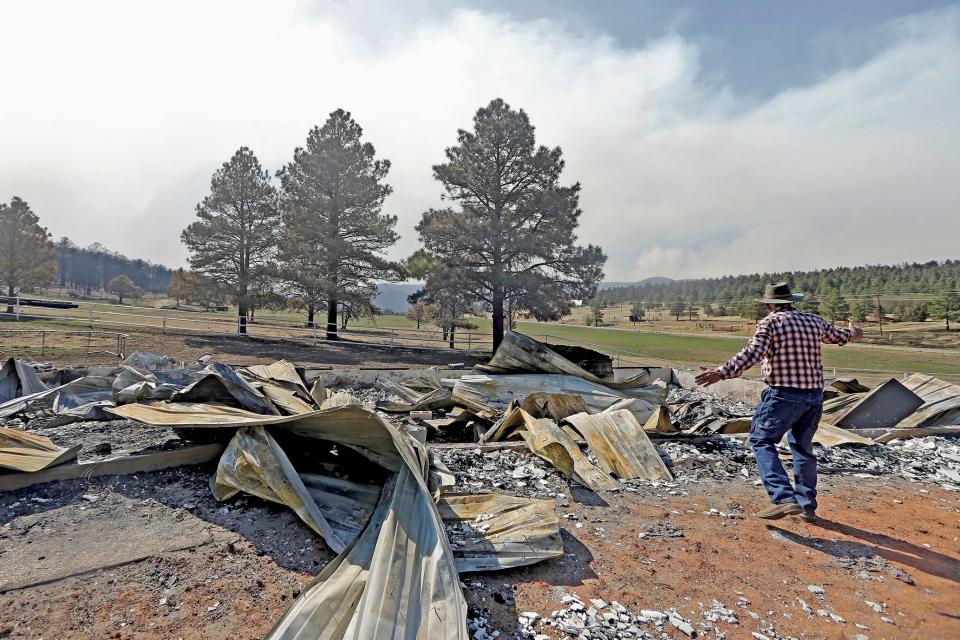 Jerry Gomez looks through the remains of his home following a wildfire in Rociada, New Mexico, on May 10, 2022. The largest wildfire burning in the United States was heading toward mountain resort towns in northern New Mexico on May 11, prompting officials to issue another set of warnings for more people to prepare to evacuate as the fast-moving fire picks up momentum. Gomez is enthusiastic about rebuilding.