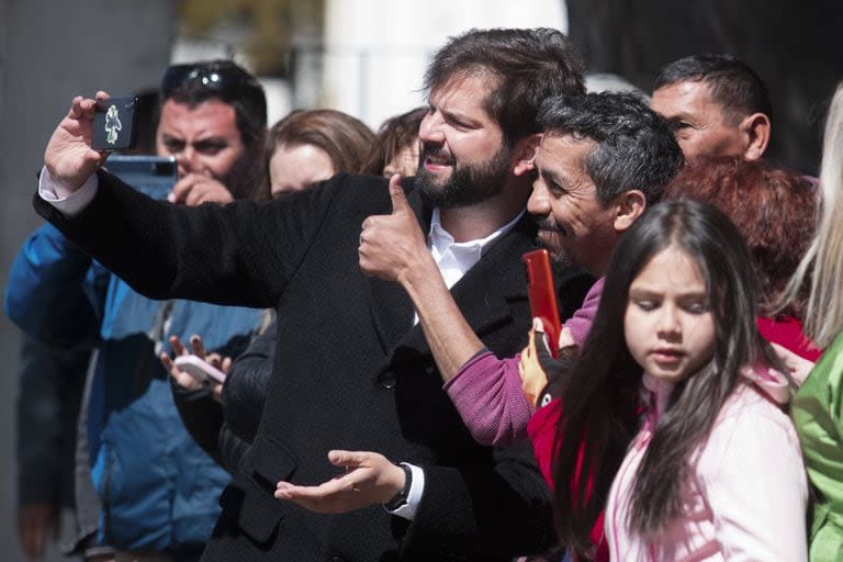 El presidente de Chile, Gabriel Boric, en el centro, posa para una foto con sus partidarios mientras llega a votar sobre el proyecto de una nueva constitución en Punta Arenas, Chile