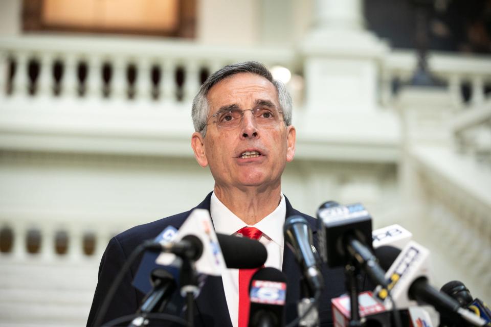 Georgia Secretary of State Brad Raffensperger addresses reporters from behind a bank of microphones during a press conference in Atlanta, Georgia.