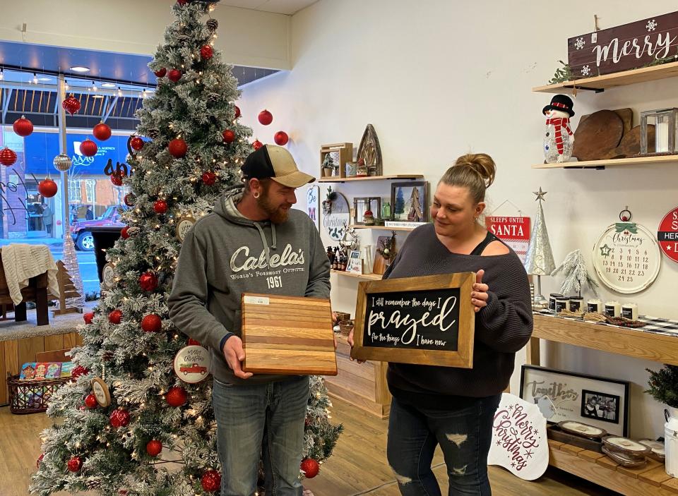 Homemade Happiness & Co. owners Brian and Kayla Moore display some of the items crafted by local vendors that are available at their Wheeling Avenue store.