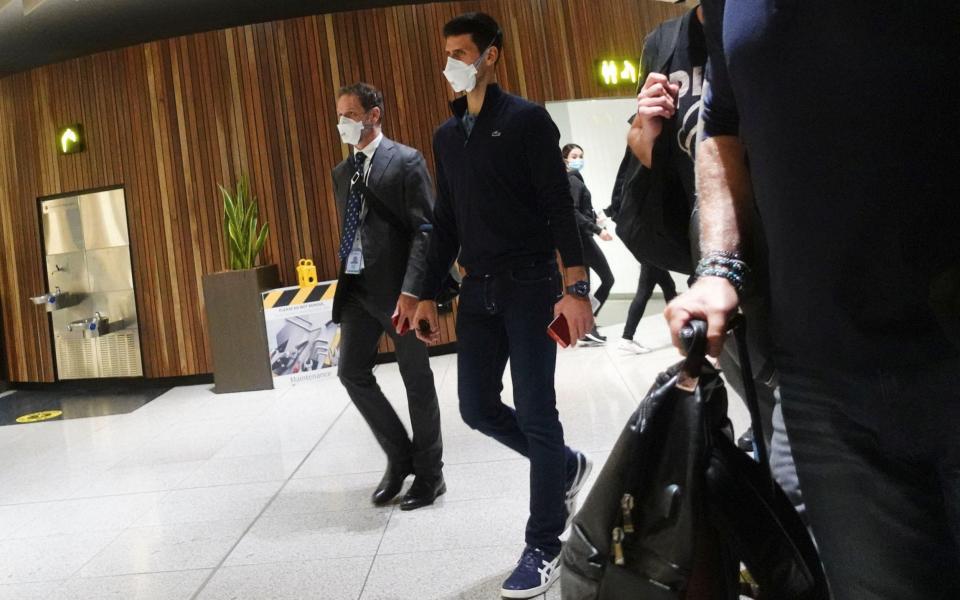 Novak Djokovic walks in Melbourne Airport before boarding a flight - REUTERS