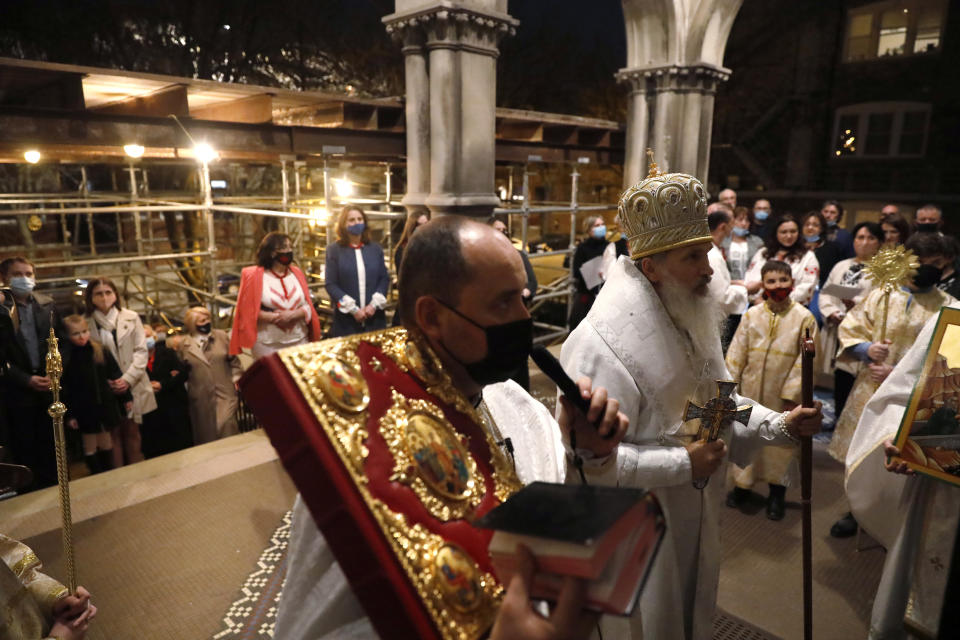 People gather at an entrance to St. Nicholas Ukrainian Catholic Cathedral as Bishop Benedict Aleksiychuk leads an Easter service Saturday, April 3, 2021, in Chicago. (AP Photo/Shafkat Anowar)