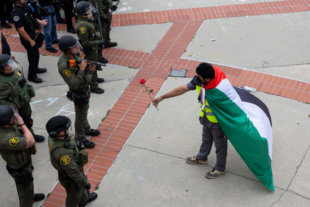  A pro-Palestinian demonstrator and police officers at the University of California at Irvine (UCI) on May 15, 2024. 