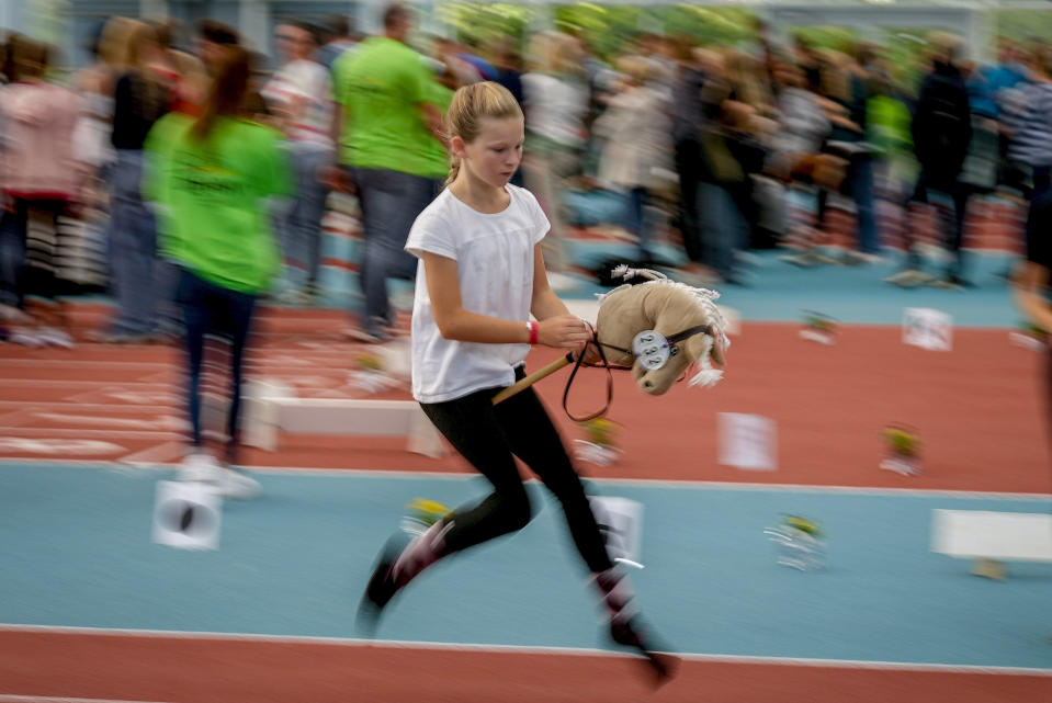 A participant competes in the dressage event at the first German Hobby Horsing Championship in Frankfurt, Germany, Saturday, Sept. 14, 2024. (AP Photo/Michael Probst)